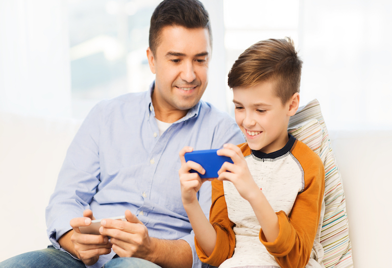 happy father and son with smartphone at home